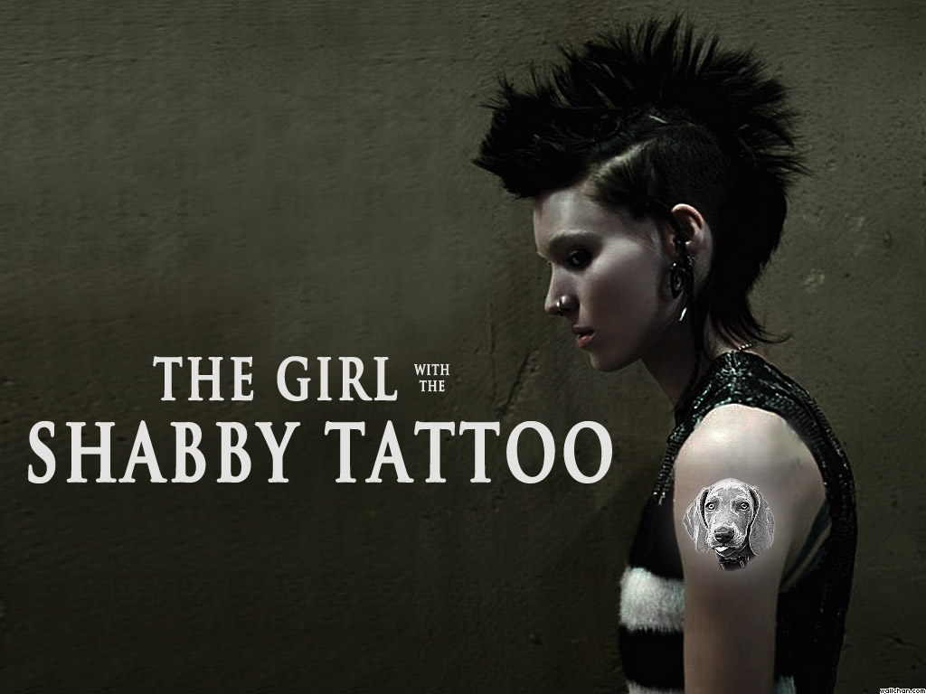 a tattoo of Shabby's head on the left arm of Lisbeth Salander